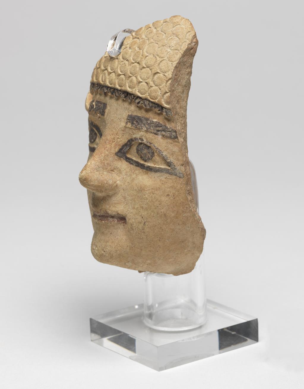 An image of Figure/Head. Male head, wearing cap. Production Place: Cyprus. Find Spot: Salamis, Temple of Apollo, Cyprus. Clay, moulded, height 101 m, width 0.077 m, 600-501 B.C. Archaic Period.