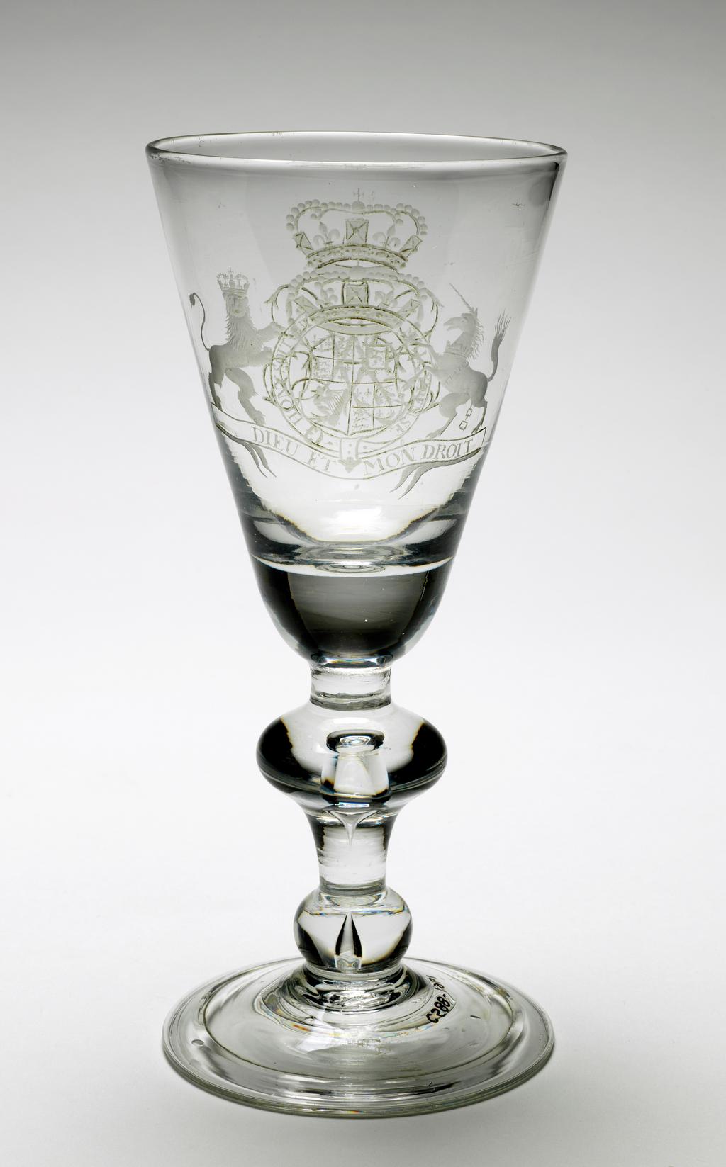 An image of Unknown. Glass Goblet. Round-funnel bowl with solid base engraved on one side with Royal Arms before 1707; on the other side a monogram (?) on cusp-knopped baluster stem. Folded foot. Bowl blown, with engraved decoration, height 20.1cm, diameter (whole) 9.2cm, circa 1700.