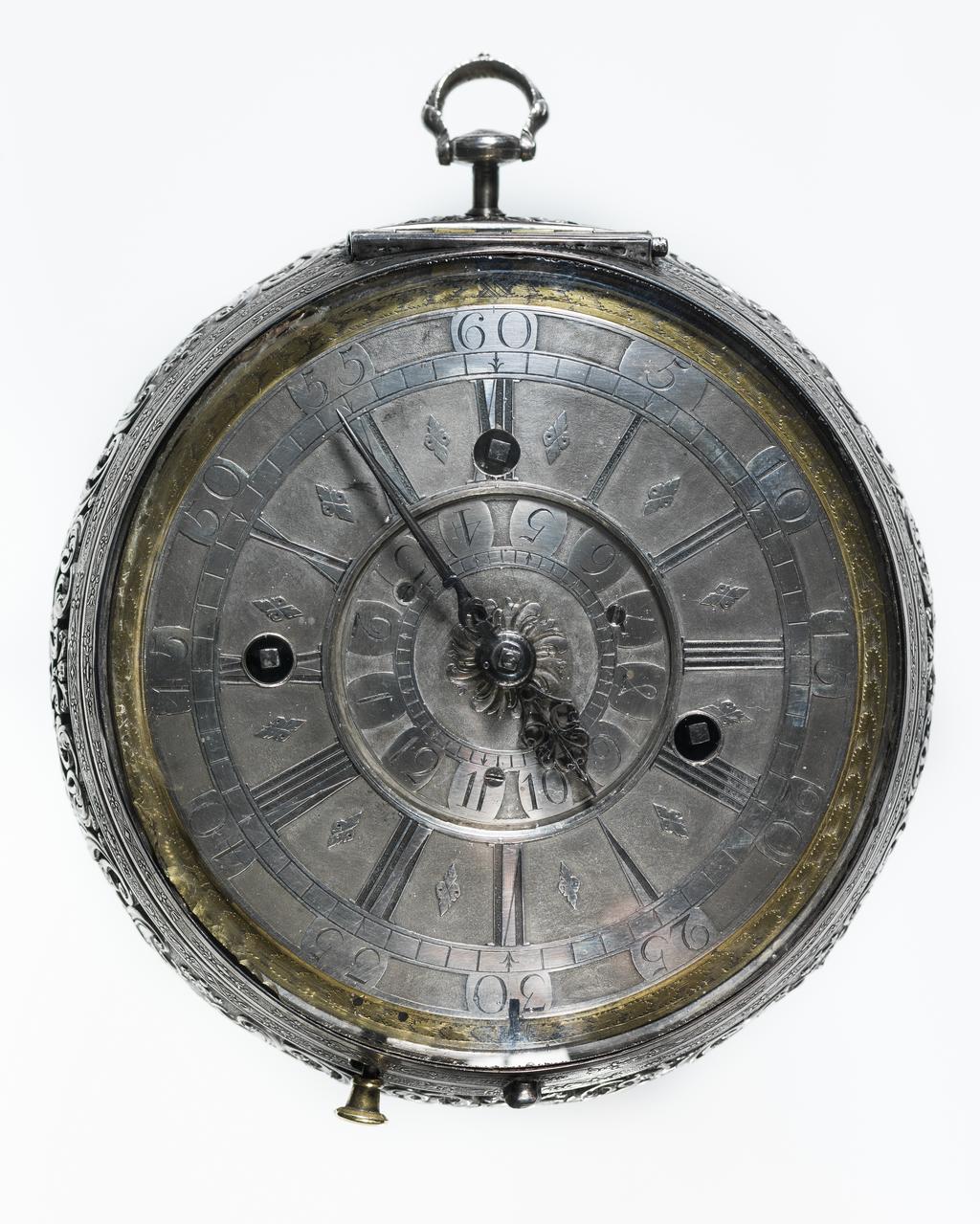 An image of Verge alarm coach watch. Movement: Thomas Windmills, London, c. 1725; case probably by Sarah Jaques and John Lee, London. Movement: brass, silver and steel, engraved ‘Thomas Windmills LONDON 7303’. Dial: silver champlevé with blued steel hour and minute hands. Case: silver, pierced and chased with four repoussé panels from Aesop’s Fables. Interior stamped with maker’s mark incuse ‘SI IL’. Case: height 13.9 cm, diameter 12.6 cm, depth 6.1 cm, circa 1725. London. 