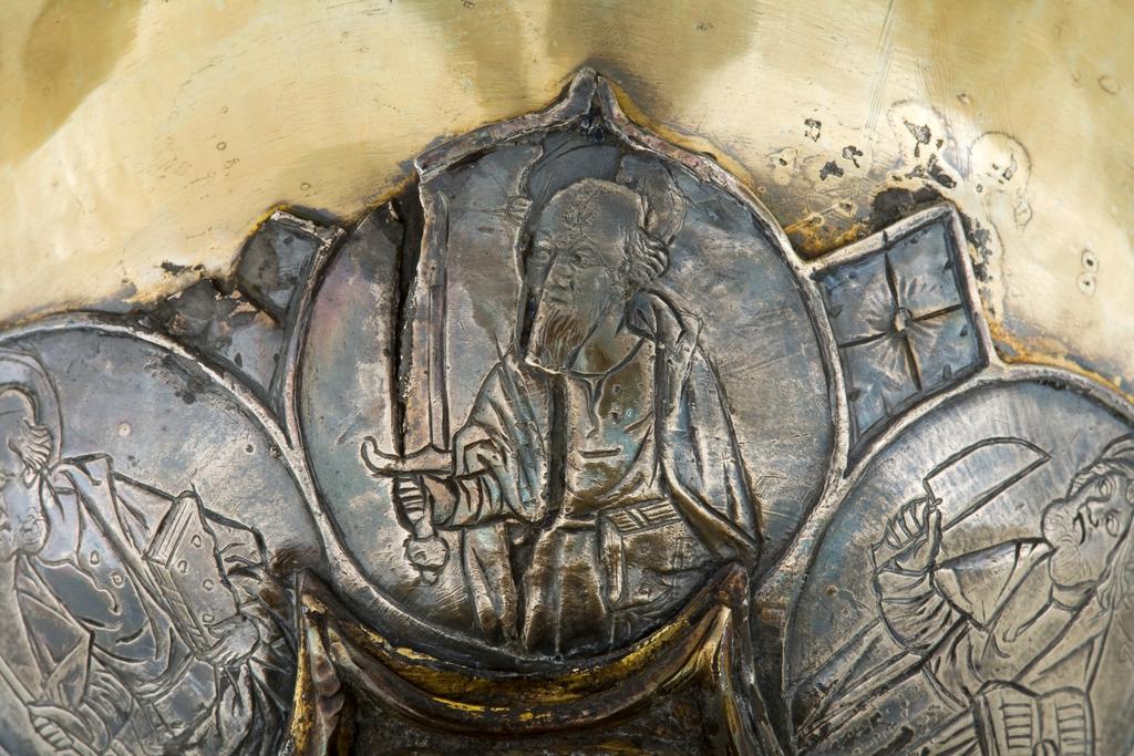 An image of Silver/Church Plate. Chalice. Petruccio Campagnini, Andrea, probably (active Tuscany, Siena, Italy). Set with six silver medallions of Christ, St Peter, St. Paul, St. John, St. Bartholomew and possibly St. Barnabus. Above the knop the stem is engraved with six male busts without nimbi; below the knop the stem is engraved with six birds. At the base of the stem are moulded borders containing a plain band engraved and enamelled with the inscription 'ANDREA * PETRUCI * DE * SENIS * ME *FECI(T). The low copper-gilt trumpet-shaped foot has a shaped circular spreading base with rim of twelve alternating semicicular and pointed lobes. It is set with six applied silver plaques with translucent enamels on sunk relief, representing the Crucifixion with Instruments of the Passion, on either side of which are the Virgin and St. John; on the opposite side are a bishop with mitre and crozier between a male and female saint. Above are smaller shaped triangular plaques enamelled with the heads of angels; and below are lozenge shaped plaques enamelled with a stylised leaf. The base stands on a foot ring decorated with moulded, beaded and dentil borders. Bowl silver-gilt with silver calyx, foot and stem of copper-gilt, decorated with embossing and chasing, and set with silver plaques with basse taille enamelling, height, overall, 19 cm, diameter, base, 12.8 cm, maximum, diameter, rim, 9.9 cm, circa 1370. Late Medieval. Gothic.