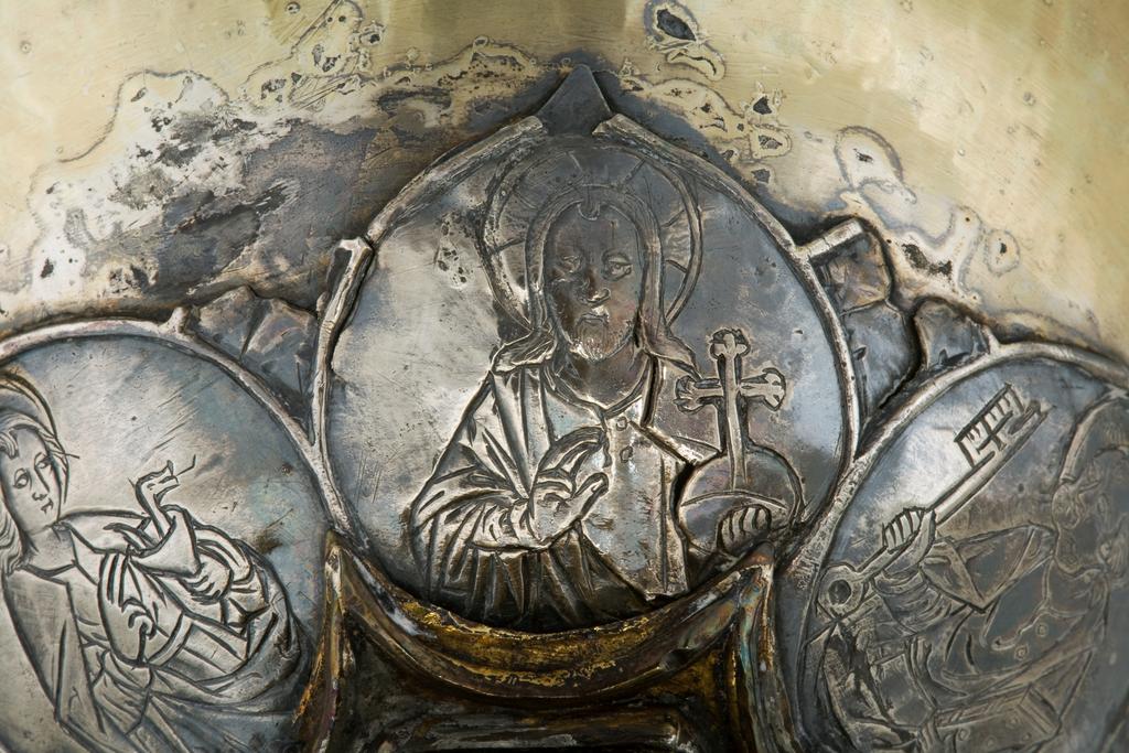 An image of Silver/Church Plate. Chalice. Petruccio Campagnini, Andrea, probably (active Tuscany, Siena, Italy). Set with six silver medallions of Christ, St Peter, St. Paul, St. John, St. Bartholomew and possibly St. Barnabus. Above the knop the stem is engraved with six male busts without nimbi; below the knop the stem is engraved with six birds. At the base of the stem are moulded borders containing a plain band engraved and enamelled with the inscription 'ANDREA * PETRUCI * DE * SENIS * ME *FECI(T). The low copper-gilt trumpet-shaped foot has a shaped circular spreading base with rim of twelve alternating semicicular and pointed lobes. It is set with six applied silver plaques with translucent enamels on sunk relief, representing the Crucifixion with Instruments of the Passion, on either side of which are the Virgin and St. John; on the opposite side are a bishop with mitre and crozier between a male and female saint. Above are smaller shaped triangular plaques enamelled with the heads of angels; and below are lozenge shaped plaques enamelled with a stylised leaf. The base stands on a foot ring decorated with moulded, beaded and dentil borders. Bowl silver-gilt with silver calyx, foot and stem of copper-gilt, decorated with embossing and chasing, and set with silver plaques with basse taille enamelling, height, overall, 19 cm, diameter, base, 12.8 cm, maximum, diameter, rim, 9.9 cm, circa 1370. Late Medieval. Gothic.