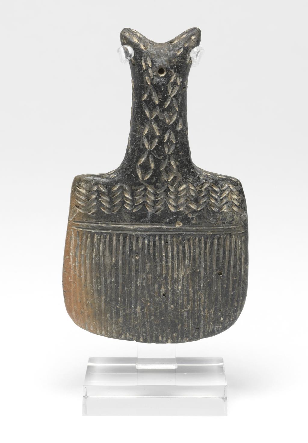 An image of Model of brush. Production Place: Cyprus. Find Spot: Vounous Cyprus; Tomb 121. Clay, red-polished ware, depth 0.012 m, height 0.099 m, width 0.058 m, 2200 to 2101 B.C. Early Cypriot II. Bronze Age.