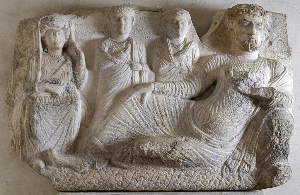 An image of Funerary equipment/grave relief. Stone relief showing a funerary banquet. Man with family, from funerary monument. Production Place/Find Spot: Palmyra, Syria. Limestone, carved and inscribed, height 0.537 m, height, relief, 0.09 m, 101-200. Middle Roman Period.