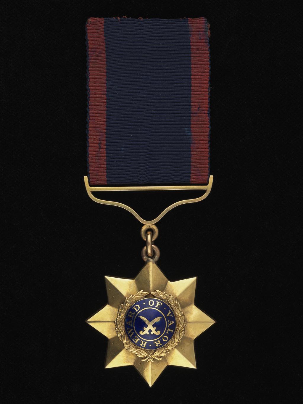An image of Medal. Indian Order of Merit, 1st Class. Calcutta mint. East India Company. Indian Army. Obverse: REWARD OF VALOR; Blue boss with crossed swords in circle with lettering around, all in gilt; wreath around and eight star points. Reverse: 1st Class; Eight-pointed star, plain save inscription. Gold, struck, weight 50.93,g, diameter 40.6 mm, 1837-1911. Notes: The Indian Order of Merit, instituted by the Honourable East India Company in 1837, is the oldest award for gallantry of the British Empire. The Order had three classes until 1912, for which medals were awarded in silver, silver and gold and gold respectively, and promotion from one class to a higher was achieved by further acts of bravery. The receipient of this medal must therefore have been awarded the Order's medal three times at some point between 1837 and 1912, when Indian troops were made eligible for the Victoria Cross thus displacing the original first class, but as the medals were issued unnamed, we do not know who the recipient was. Lester Watson purchased the medal from the London dealers Baldwin in 1927.