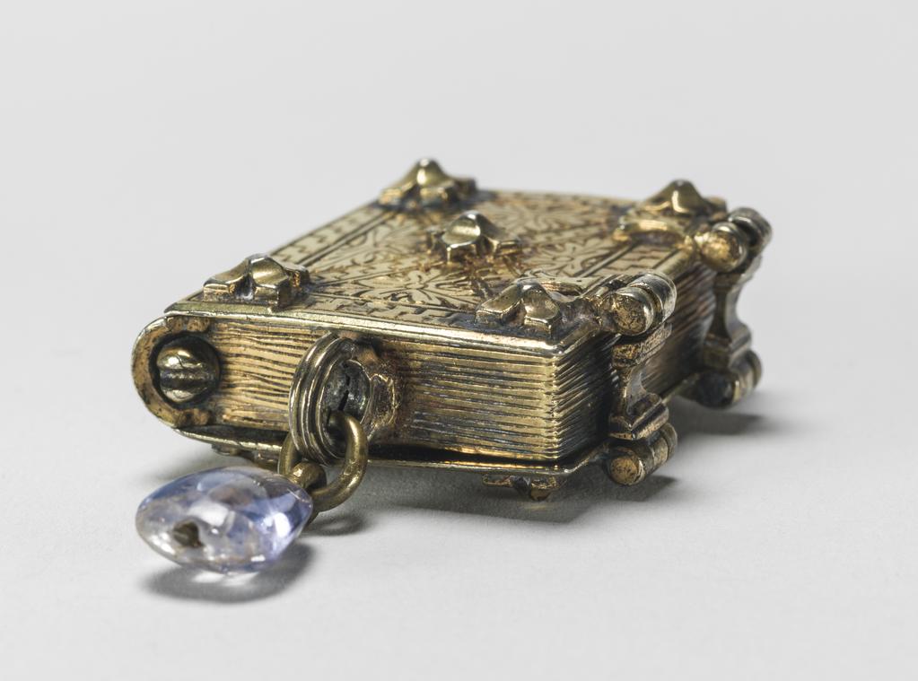 An image of Pendant Book. Jewellery/Pendant. Silver-gilt, with leaves made of silver and engraved with scenes from the Passion. Perhaps for attaching to a rosary, with pendant amethyst. Scenes: Annunciation, Nativity, Last Supper, Agony in the Garden, Kiss of Judas, Christ before Pilate, Scourying of Christ, The Mocking of Christ, Christ Carrying the Cross, the Erection of the Cross, Christ being Nailed to the Cross, the Crucifixion Deposition, Entombment, Resurrection, Christ Child Enthroned, a Pope and a female Saint. Silver-gilt, height, whole, 6.0 cm, width, whole, 2.8 cm, circa 1500- circa 1700. German.