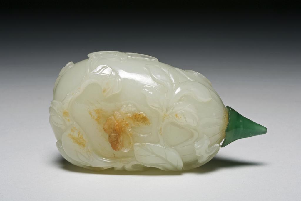 An image of Snuff bottle. Nephrite of white colour in the form of a fruit with leaves, tendrils and a butterfly in relief. Height 7.1 cm, 1760-1880.  Production Place: China.