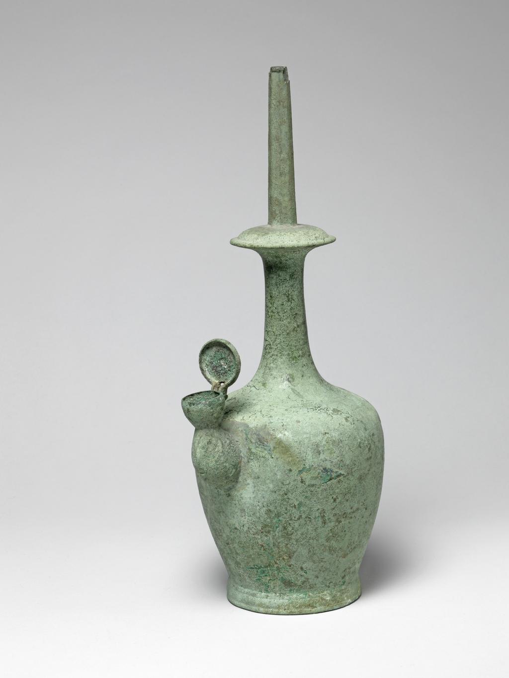 An image of A bronze Kundika of usual shape with octagonal spout, lid on lateral spout intact, covered with even pale-green patina. Circa 935-1392. Korean.