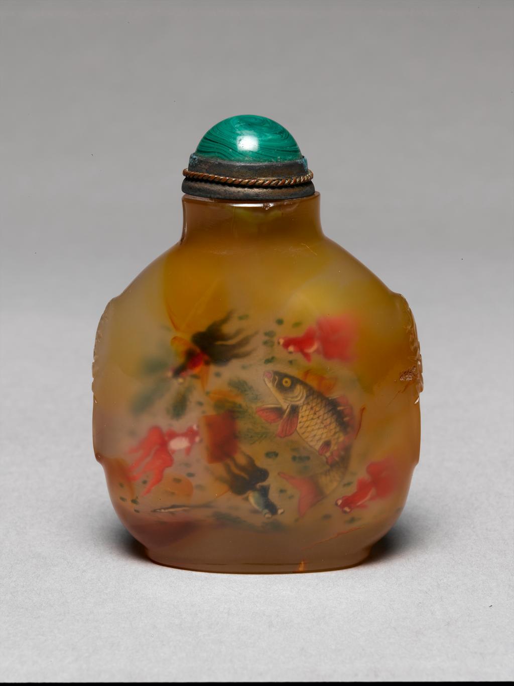 An image of Snuff bottle. Quartz chalcedony carved on the sides with mask and mock ring handles and painted inside with fish swimming amid aquatic plants, signed 'Ye Zhongsan', dated 1918. The bottle is 1760-1880. Chinese.