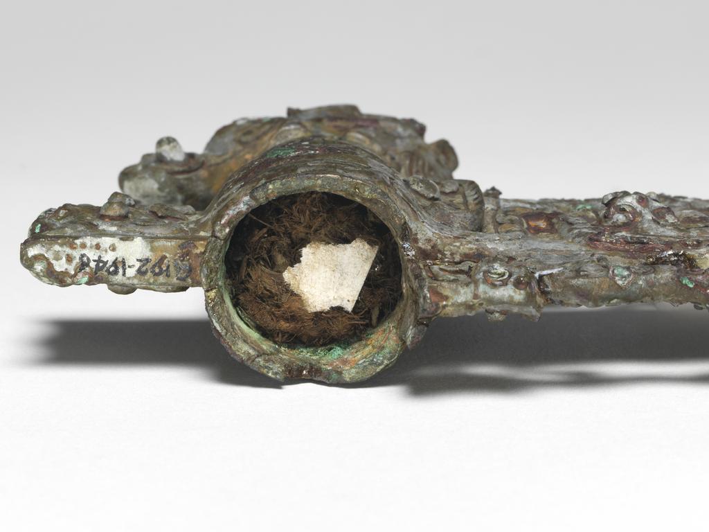 An image of Axe head. The blade, socket, and socket cap all one piece of metal. The blade is flanked by two tigers. On the blade is a coiled dragon, a conventionalised dragon's head, and a t'ao t'ieh mask in the piece of blade at the back. On the cap is an elephant's head with horse's legs and a tiger's head at the back. Bronze, height 11.1 cm, length 14.6 cm, circa 500-249 B.C. Chou dynasty (1122-249 BC). Chinese Warring States period.