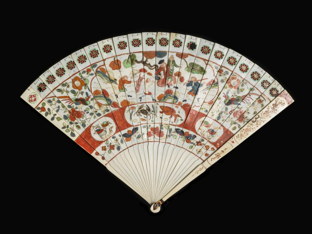 An image of Fans/ Wedge-shaped brisé fan. Unknown maker. Front: The decoration is arranged in four horizontal bands. 1. Geometrical motifs, pierced and painted red, green and gold. 2. A European outdoor scene in which two servants bring a pig or tiger to a pipe-smoking gentleman seated beside a standing gentleman who is extending his arm towards another servant, who carries a stick. On both sides there is a long-tailed exotic bird among flowers and foliage. 3.Three oval panels reserved in a red band, the centre oval is painted with a crab and a fish, the others with stylized plants. 4. Foliage and flowers. The area below the shoulder is undecorated. Reverse: The same design reversed. Guards: Prunus sprays. Ivory sticks, pierced, painted in red, green, slate blue, brown, black, and gold. Guards plain ivory painted in brown, red, green and gold, the head strengthened with tortoiseshell. (20+2) Gold stringing. Rivet of brass? Length, guards, 25.6 cm, circa 1710- circa 1720. Production Note: Chinese for European market, possibly made in China and painted in Holland.