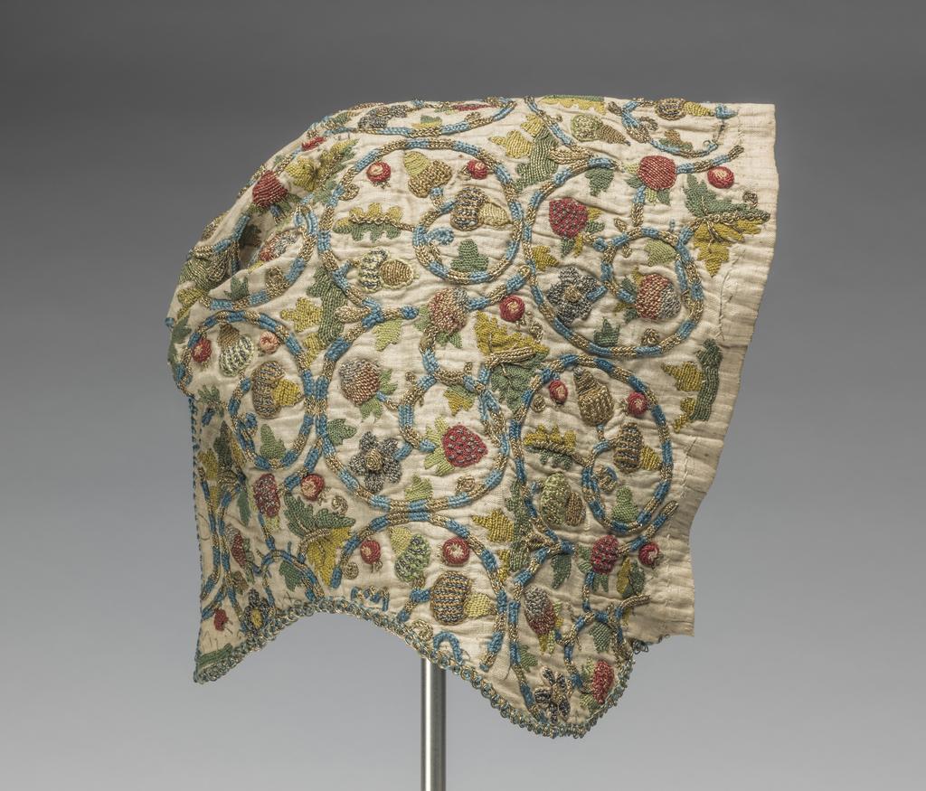 An image of Textiles/Woman's coif. Linen, polychrome embroidery in silk, silver and silver gilt thread. Stitches; braid, buttonhole, chain, double chain, ladder, plaited braid, stem, trellis, bosses. Design, circular coiling stems terminating in alternating sprays of oak leaves and strawberries. Open top seam, front edge finished with gilt thread and dark blue silk. Height, whole, 8 in, width, whole, 8 in, circa 1575- circa 1624. English.