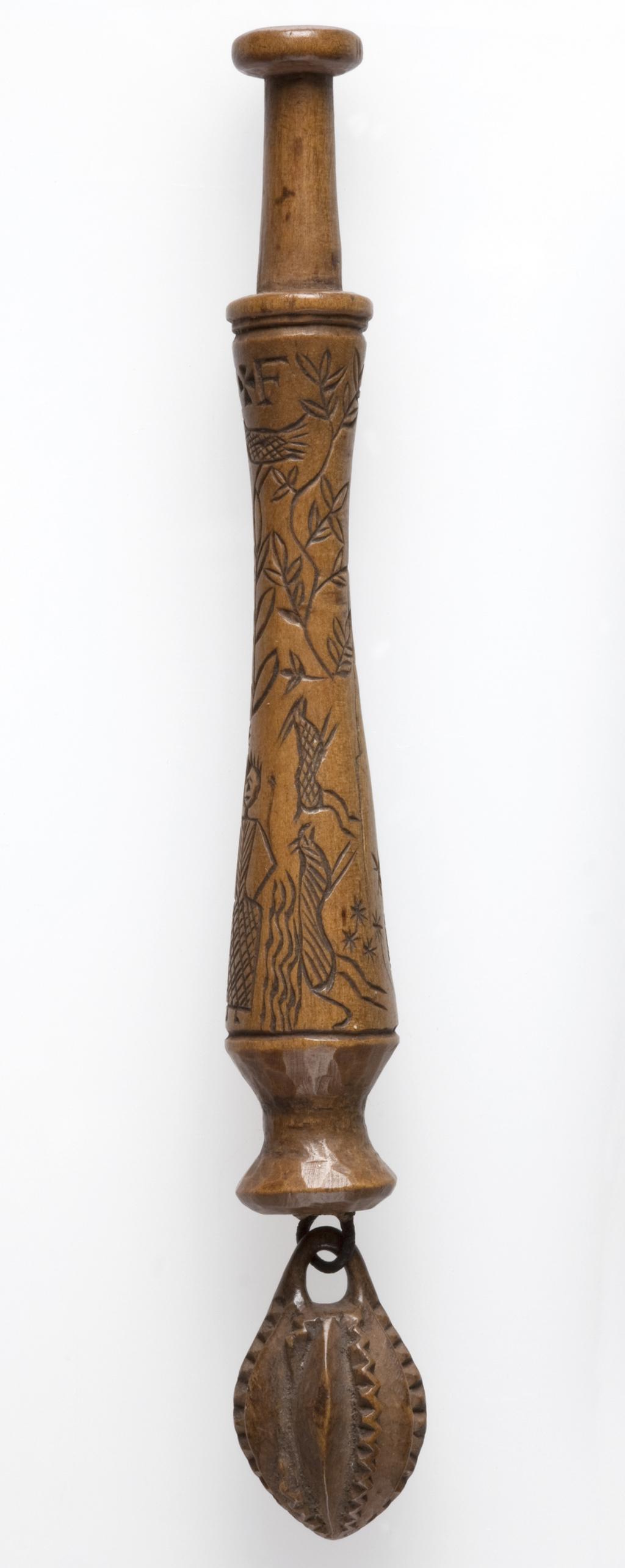 An image of Lace Bobbin. Unknown maker, Bedfordshire, Dunstable Downs. Wood, carved with figures (maker and his wife), sheep, (his) dog, bushes and the sun, moon and stars. Circa 1795. No dimensions.