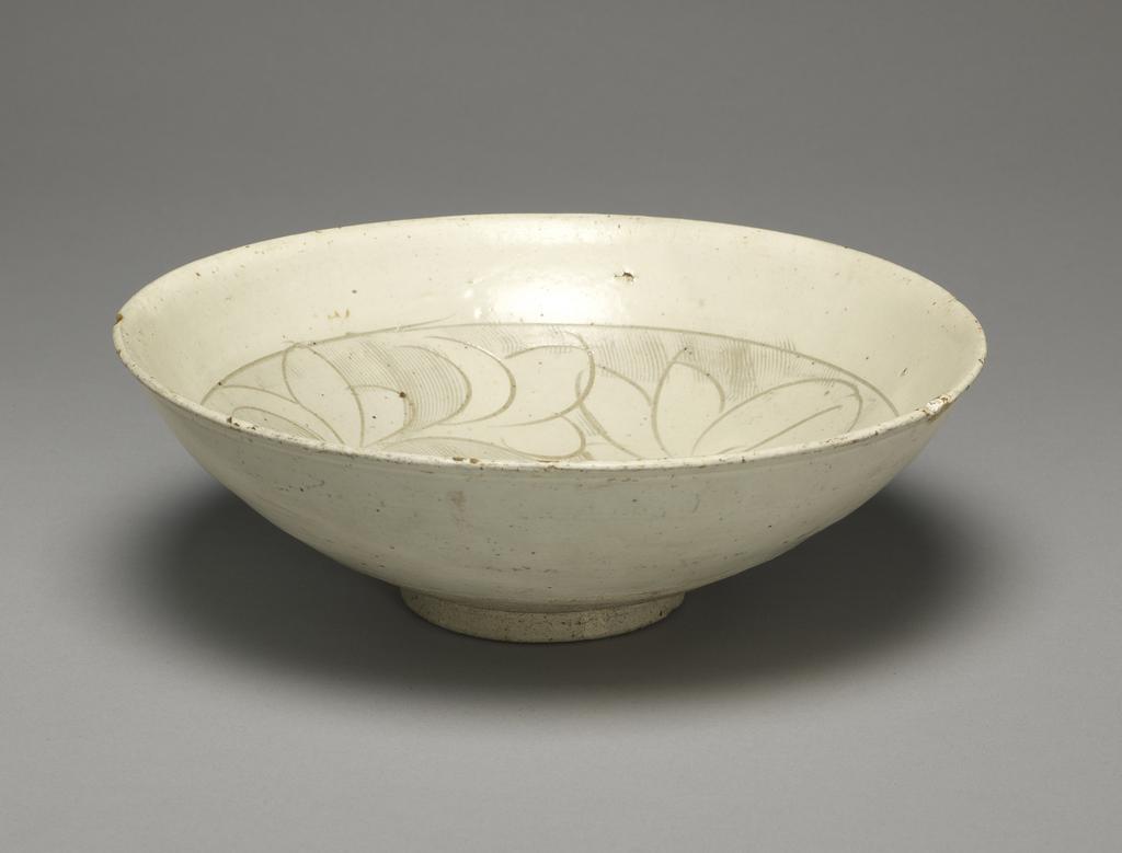 An image of White stoneware bowl. Tz'u chou ware. Unknown production, China. With an incised and combed white slip decoration, in the form of a flower. Stoneware, slip-coated, incised, height 7 cm, diameter 21.6 cm. Song Dynasty (960-1279). Acquisition Credit: Given by Oscar Raphael.