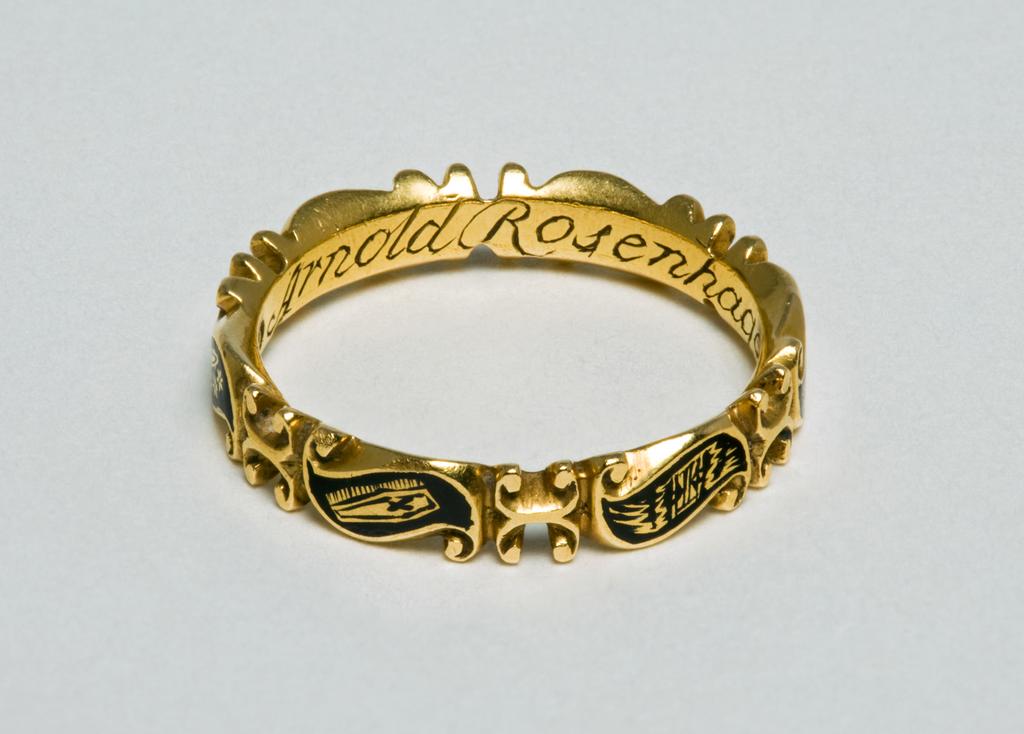 An image of Ring. Unknown Maker (English). Hoop formed of six scrolls each bearing a symbol: a skull, crossbones, a spade and mattock, an hour-glass, a coffin, and a crown of stars. Inscribed inside hoop: Arnold Rosenhagen ob Dec: 1743 æt 45. Gold, height  4.0 mm, depth 2.0 mm, length 20.5 mm, 1743.
