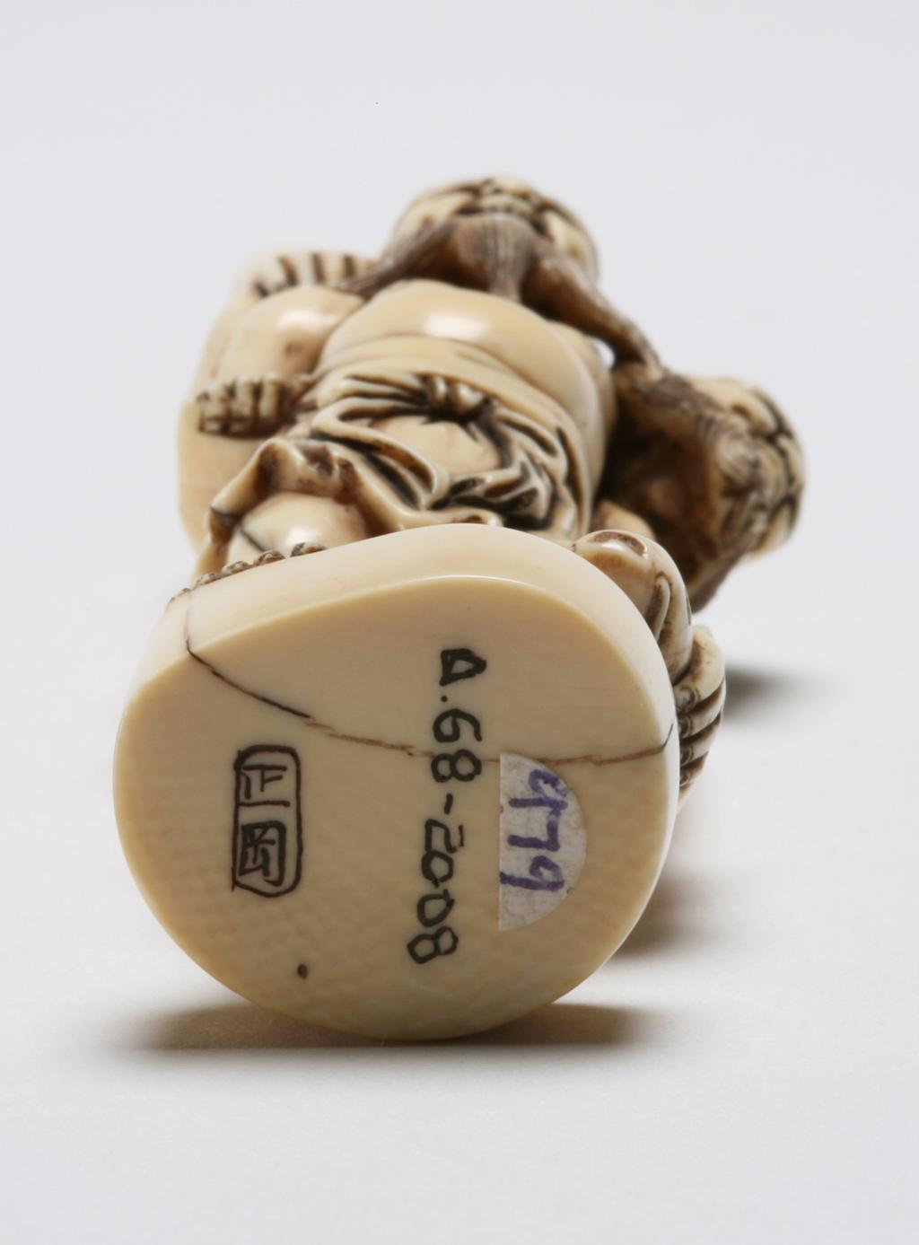 An image of Netsuke. Unknown maker, Japan. Tenaga with long arms has caught a fish, on the back of the long legged Ashinaga. Ivory, carved, 1970-2000.