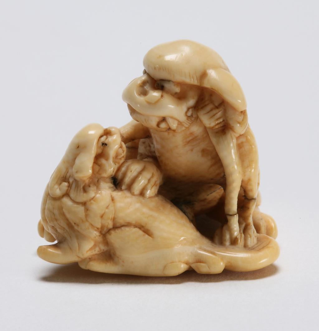 An image of Netsuke. A Shishi with its cub. Unknown maker, Japan. Ivory, carved, 1800-1850. Edo period.