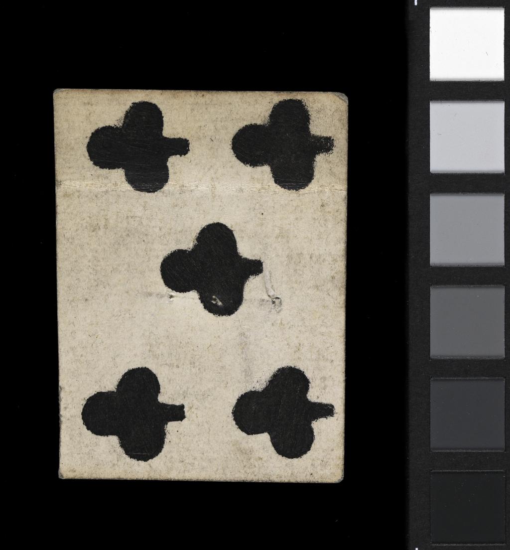 An image of Fragment of the Ten of Clubs. The upper half of the card, with the upper edge also missing. Five out of the ten pips are present. The position of the central pip in the upper portion of the card indicates that there would have been a second pip below and confirms the card as the Ten of Clubs rather than the Nine of Clubs. There is a crease across the card where it has been folded. There are two holes at the centre, which are most likely stitching holes relating to the secondary use of the card as a stiffening material in bookbinding. See W.M. Fletcher, who describes other playing cards and MSS found near staircase A at Trinity College in 1902 which are ‘pierced with stitching holes containing fragments of thread’ and states that, ‘These no doubt represent some rubbish from destroyed book bindings, for it should be remembered that this staircase provided a back way to the College Library when it was housed in this block’. Hand-coloured woodcut on pasteboard. French, 17th century.