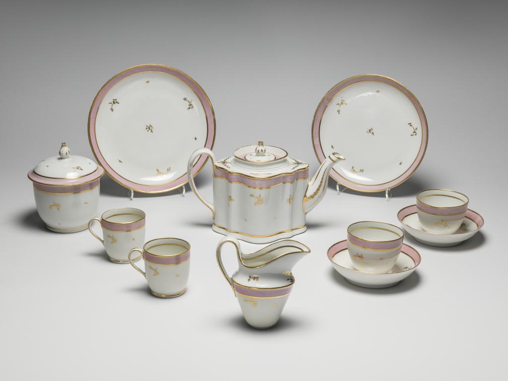 An image of Tea Service/Tea Set. New Hall Porcelain Factory, Staffordshire. Comprising a teapot and cover of 'silver' shape, a milk jug, sugar basin and cover, a slop basin, two plates of different sizes, two tea bowls, two coffee cups and two saucers. Each piece is decorated with a wide band of pink enamel between narrow gold bands and with scattered floral sprigs in gold. In addition, the milk jug has two sprays of leaves below the lip, and the teapot has sprays of leaves and formal ornament on the shoulder and further formal ornament on spout and handle. Pattern no. 223. Hybrid hard-paste porcelain, moulded, and painted lead overglaze, decorated with pink enamel and gilt, height, teapot, 14.4 cm, length, teapot, 24.1 cm, height, sugar basin, 13.5 cm, diameter, sugar basin, 10.3 cm, height, slop basin, 7.4 cm, diameter, slop basin, 15.2 cm, height, milk jug, 11.5, cm, height, plate, 3.2 cm, diameter, plate, 23.8 cm, height, plate, 3.1 cm, diameter, plate, 20.1 cm, height, coffee can, 6.6 cm, height, tea bowl, 6.1, cm, diameter, tea bowl, 7.6, cm, height, saucer, 3.2, cm, diameter, saucer, 13.1, cm, circa 1785. Rococo.