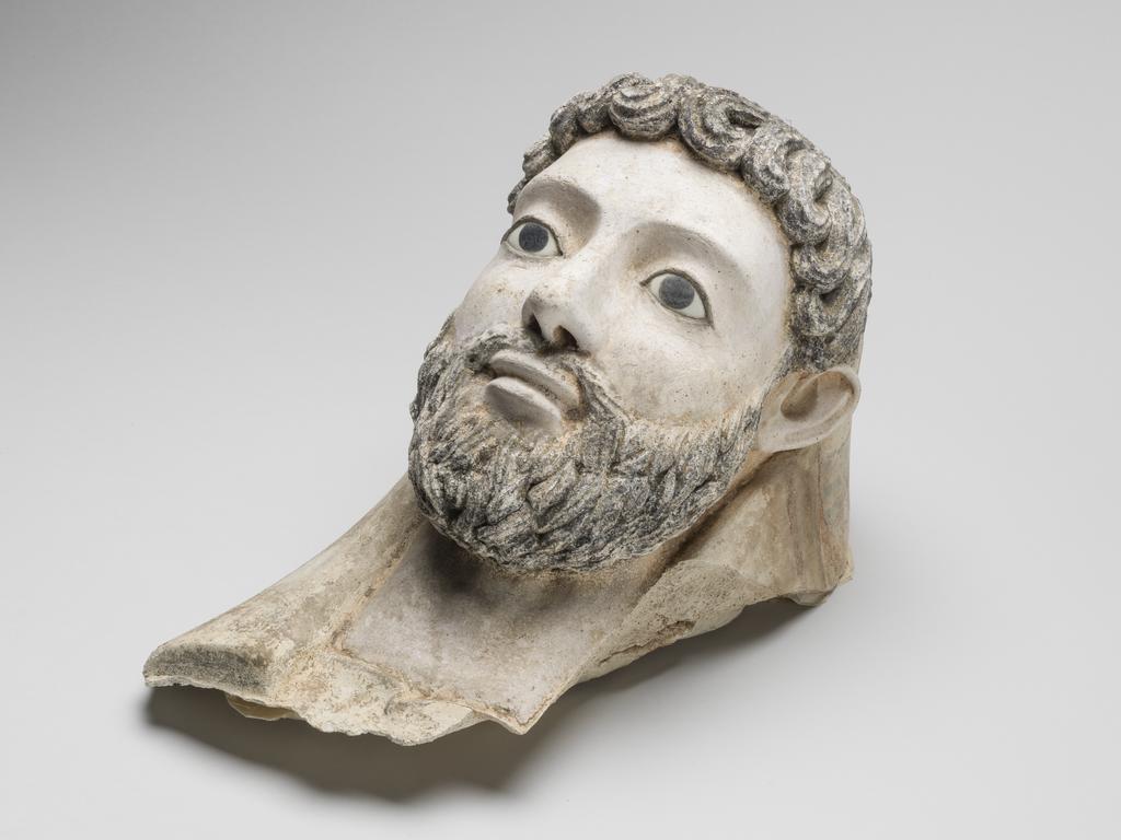 An image of Funerary equipment/Coffin. Face mask, male bearded, inlaid eyes, with part of mummy case attached. Height 34 cm, circa 150. Roman Period. Find Spot: Egypt.