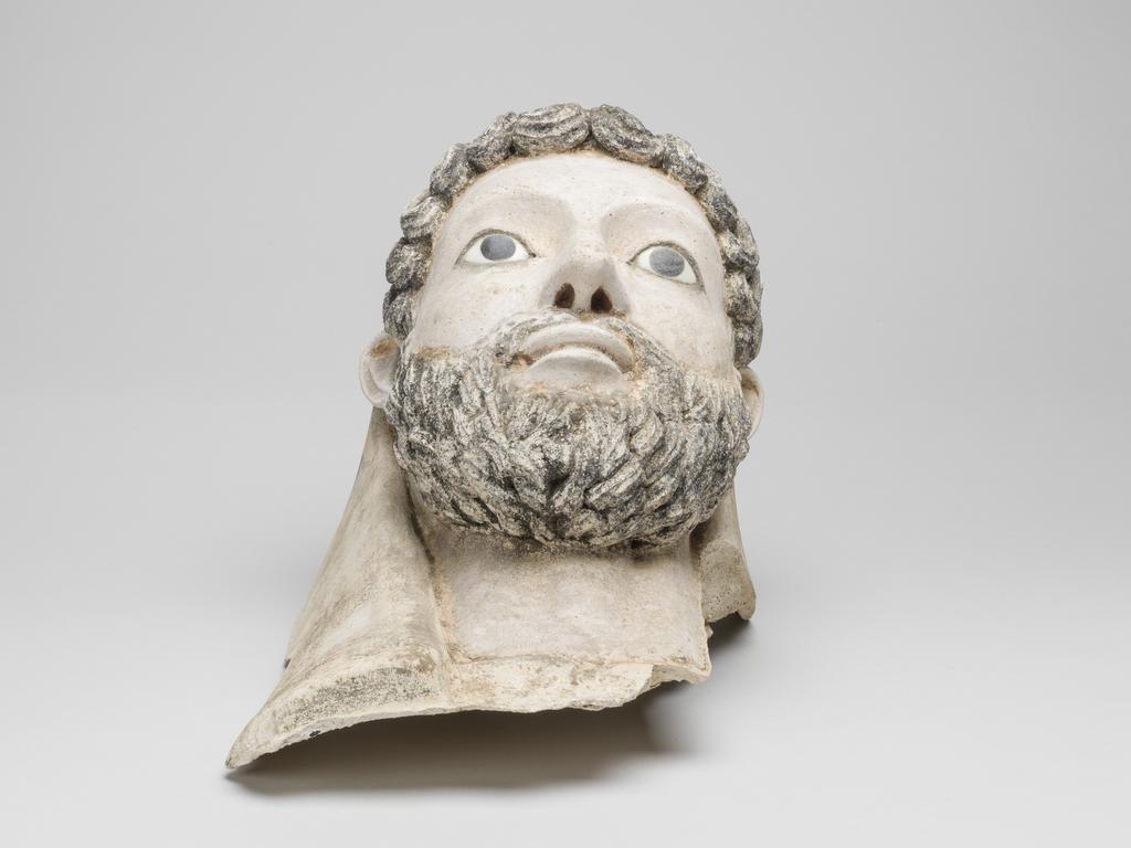 An image of Funerary equipment/Coffin. Face mask, male bearded, inlaid eyes, with part of mummy case attached. Height 34 cm, circa 150. Roman Period. Find Spot: Egypt.