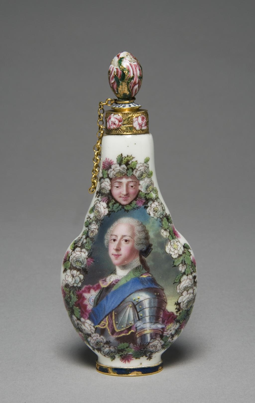 An image of Scent Flask. Capodimonte Porcelain Factory. Soft-paste porcelain, moulded, painted overglaze in enamels with gold mounts. Stopper, attached by a chain, is engraved and decorated in enamels. Height 10.6cm, width 4.7cm, depth 2.5cm, circa 1752-1755, the mounts are circa 1755-1760. Decorated on one side with a portrait of Prince Charles Stuart, the Young pretender (1720-88), and on the other with the arms of Lady Mary Hervey (1700-68), widow of John, Lord Hervey of Ickworth. Capodimonte, with London mounts.