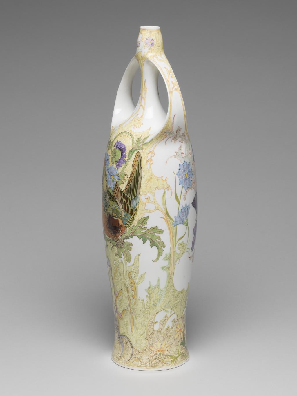 An image of Pair of two-handled balaster vases. Tegel en Fayencefabriek Amphora Factory, Oegstgeest. Designed by J. Jurriaan Kok (Dutch, 1861-1919). Painted by Samuel Schellink (Danish, 1876–1958). C.28-2014: Tall eggshell porcelain vase, baluster shape, hand-painted in polychrome enamels with bird, poppy and foliage motifs in Art Nouveau style. Circular in plan, with tall gently-concave body rising to a long narrow neck, the top of the neck slightly wider than the bottom. Two strap handles, cast with the body, rise from the shoulders and rejoin the vase towards the top of the neck. The overall form suggests an erect female body with arms raised to her head. Decorated with a finely painted flowing floral design. On one side is a green-headed songbird which appears to be flying out of the body. On the other side is a large spray of purple and light blue oriental poppies. Eggshell porcelain, decorated underglaze in polychrome enamels with hand-painted motifs, height 36.5 cm, base width 8.5 cm, circa 1914.C.29-2014: Tall eggshell porcelain vase, baluster shape, hand-painted in polychrome enamels with bird, poppy and foliage motifs in Art Nouveau style. Circular in plan, with tall gently-concave body rising to a long narrow neck, the top of the neck slightly wider than the bottom. Two strap handles, cast with the body, rise from the shoulders and rejoin the vase towards the top of the neck. The overall form suggests an erect female body with arms raised to her head. Decorated with a finely painted flowing floral design. On one side is a black-headed songbird which appears to be flying out of the body. On other side is a large spray of orange oriental poppies. Eggshell porcelain, decorated underglaze in polychrome enamels with hand-painted motifs, height 36.5 cm, base width 8.5 cm, circa 1914.