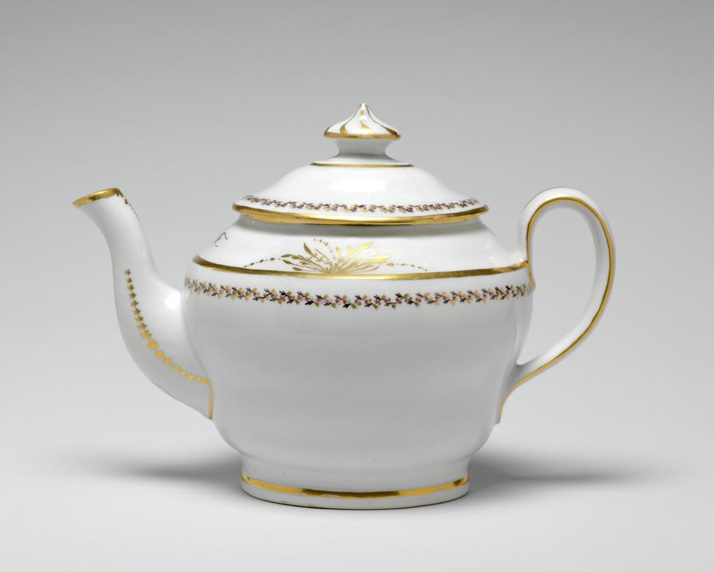 An image of Teapot and stand. New Hall Porcelain Factory, Staffordshire. The teapot and cover (A) are of oval ogee form. The stand (B) is oval with sloping sides and flat base. There are ten holes forming an ellipse surrounding one hole behind the spout, one ventilation hole in the cover, and anothe under the knob. The exterior of the pot is decorated below the shoulder by border comprising a wavy black stem with tiny trefoil leaves, puce berries, and gold trefoil leaves. Above the shoulder there is an an arrangment of gold foliage on each side of the pot and a gold sprig at each end. Gold bands run found the footring, the shoulder, the rim, the sides of the handle, and the tip of the spout. There is a vertical gold line down the back of the handle. Each side of the spout is decorated with a row of gold stars over a line which runs on round its junction with the body. Below the lip there is a gold wavy dotted line over a vertical row of narrow leaves altenating with spots. The cover is decorated en suite, and has eight swirling gold lines radiating from the top of the knob. The stand has a central stylized star-like flower surrounded by an oval gold band, a matching border, and a gold band on the edge. Pattern no. 280. Hybrid hard-paste porcelain, moulded, glazed, painted overglaze with black and puce enamel, and gilded. Height, teapot, 17.5 cm, length, teapot, 24.2 cm, height, stand, 2 cm, length, stand, 17.7 cm, width, stand, 14.6 cm, circa 1797-1803.