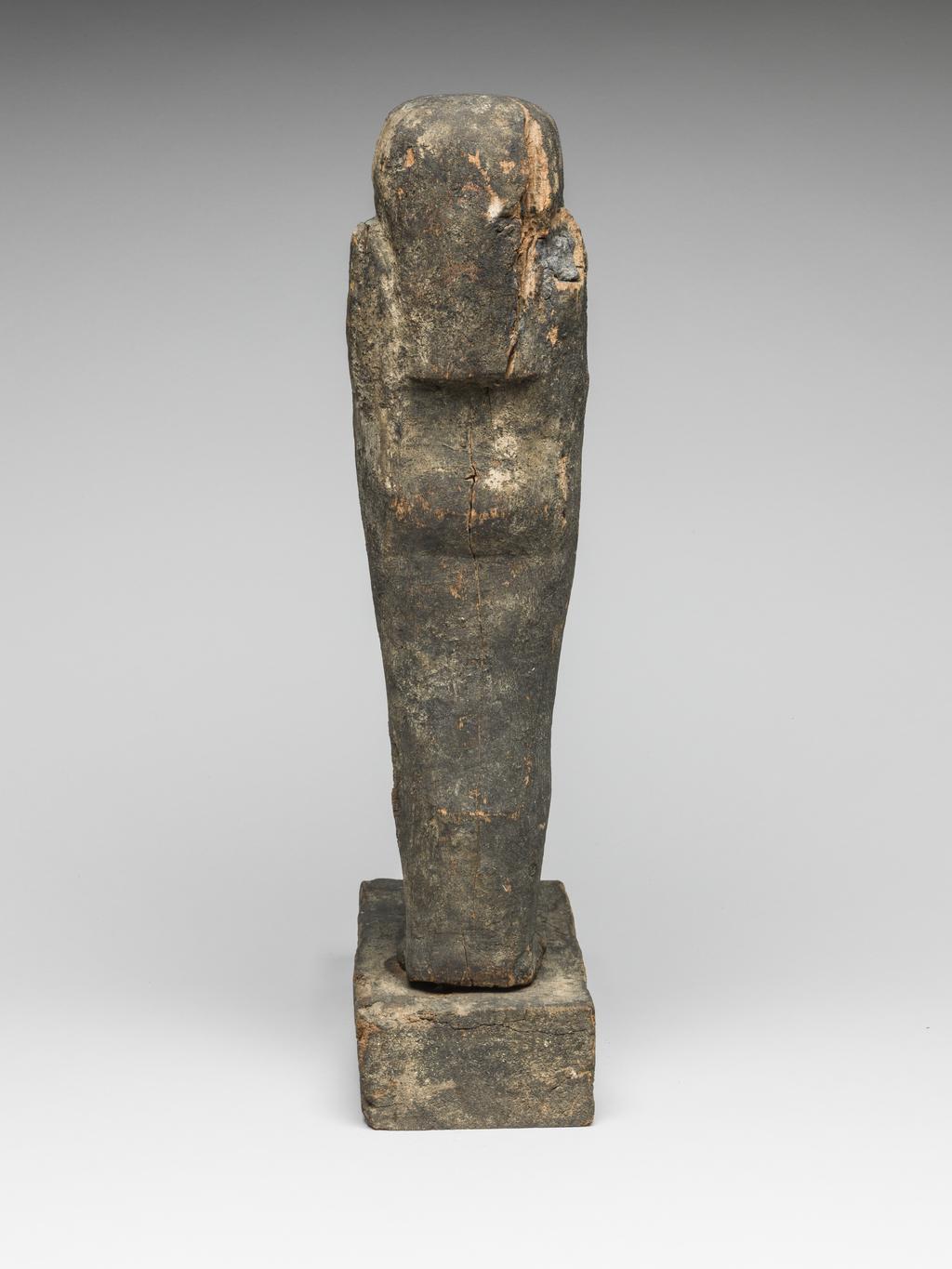 An image of Figure. Qebehsenuef. Son of Horus, falcon headed mummiform figure, standing on rectangular base, black resin coating, buried with Nakhtefmut. Production Place: Egypt. Find Spot: Ramesseum, Thebes, Egypt. Wood, carved, depth 21.2 cm, width 8 cm, height 38.5 cm, circa 923 B.C. Twenty-second Dynasty; Third Intermediate period.