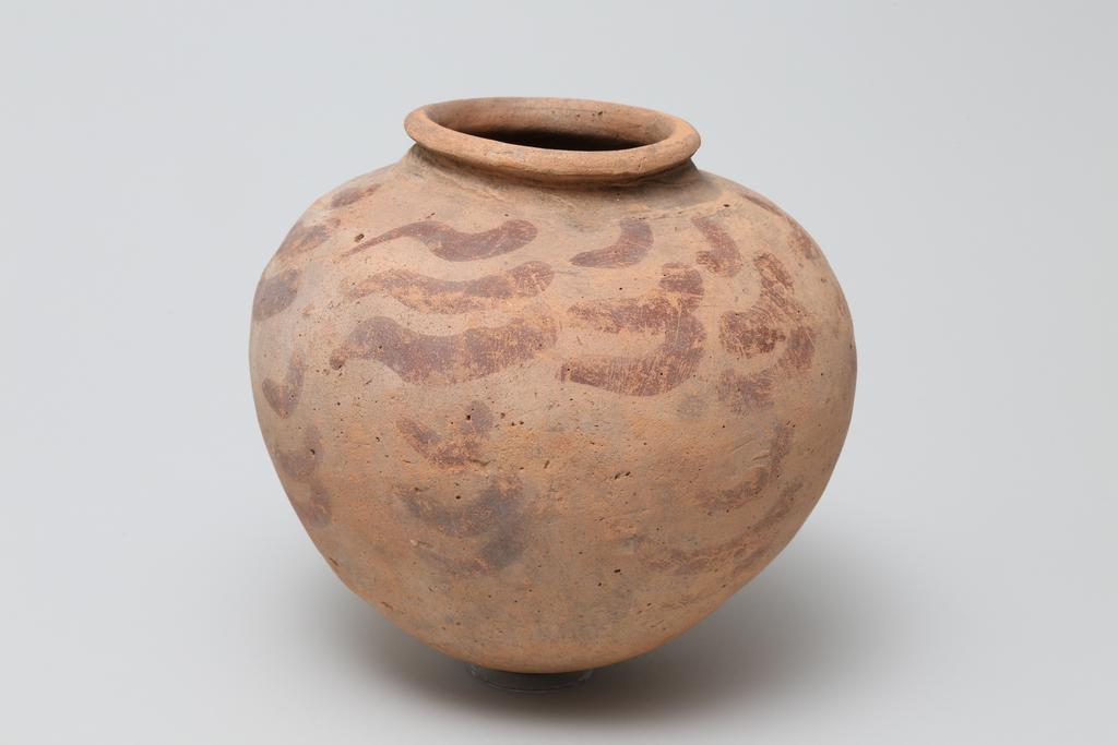 An image of Vessel. Jar, broad shouldered, globular form, with comma shaped decoration in red paint. Production Place: Egypt. Find Spot: Ballas, Egypt. Height, 0.155, m. Predynastic period.