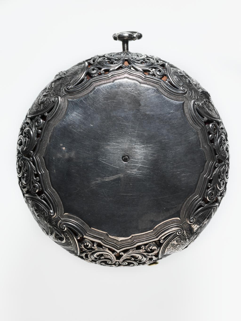 An image of Verge alarm coach watch. Movement: Thomas Windmills, London, c. 1725; case probably by Sarah Jaques and John Lee, London. Movement: brass, silver and steel, engraved ‘Thomas Windmills LONDON 7303’. Dial: silver champlevé with blued steel hour and minute hands. Case: silver, pierced and chased with four repoussé panels from Aesop’s Fables. Interior stamped with maker’s mark incuse ‘SI IL’. Case: height 13.9 cm, diameter 12.6 cm, depth 6.1 cm, circa 1725. London. 