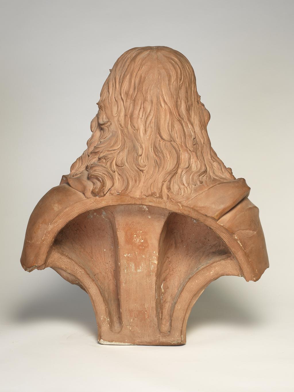 An image of Bust/Sculpture. John Milton (1608-1674). Rysbrack, John Michael (Briitsh, 1694-1770). The sitter is turned front, facing and looking slightly right. He is bare-headed, and his hair is falling long over the shoulders. He is clean-shaven. The sitter wears a doublet, with wide, falling-band collar, and drapery passing over the right shoulder, and under the left arm. The bust terminates in a low square base, inscribed on the front 'MILTON'. Terracotta, height 23 1/2 inches, dated 1738.
