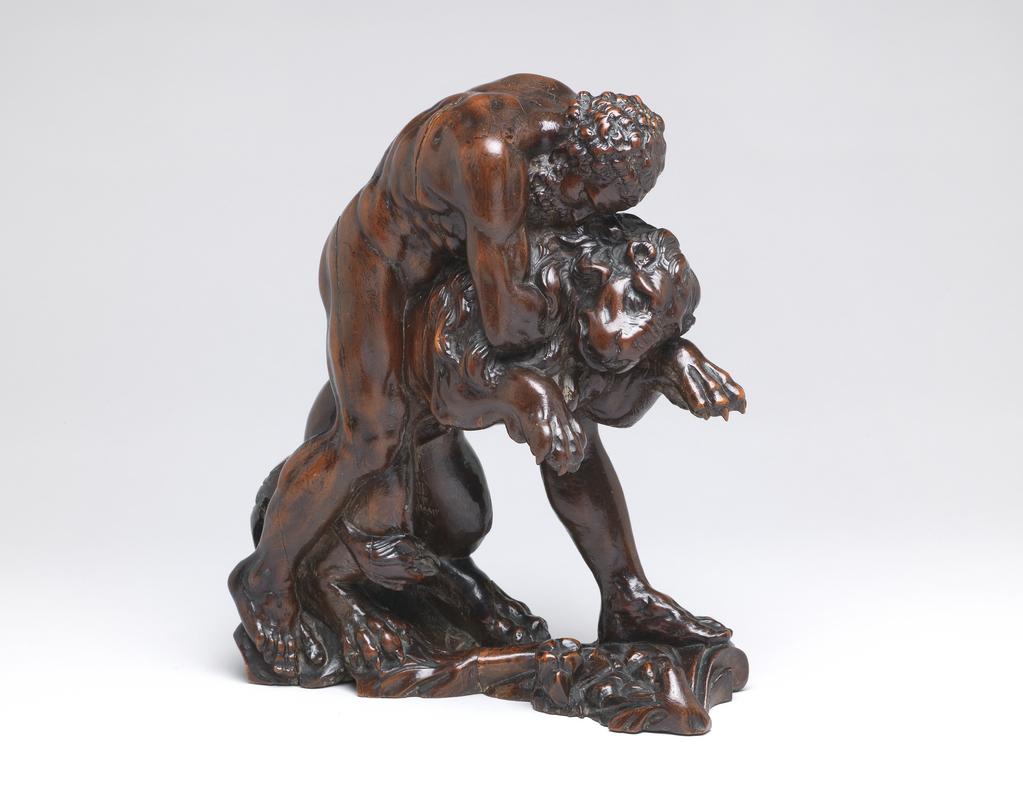 An image of Sculpture/Figure. Hercules and the Nemean Lion. Both Hercules and the Nemean lion are facing to the left. He stands astride the lion, with his left leg forward, grasping it round the throat with both arms and forcing it backwards so that both its front paws are in the air. The narrow base is carved with foliage which rises up to support the lion's rear quarters, and is there cut off. Fruitwood, carved in the round, and with a highly polished surface, height, whole, 25.0 cm, length, whole, 24.6 cm, after 1550, second half of the 16th century of later. Attribution: Purchased by Boscawen as School of Michelangelo or perhaps Bertoldo.