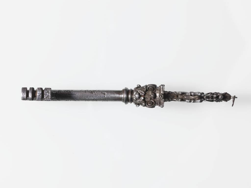 An image of Key. Iron, with piped stem, collar in the form of a Corinthian capital and bow composed of two prancing horses back to back surmounted by a mask, at the top, a ring for suspension. Circa 1500-1600. French.