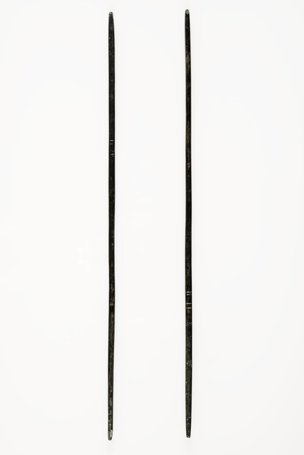 An image of A pair of black bronze chop sticks, with a square cross section at the top. The lower part is round, with two pairs of notches as the owner's mark. Beautifully balanced. Korean?