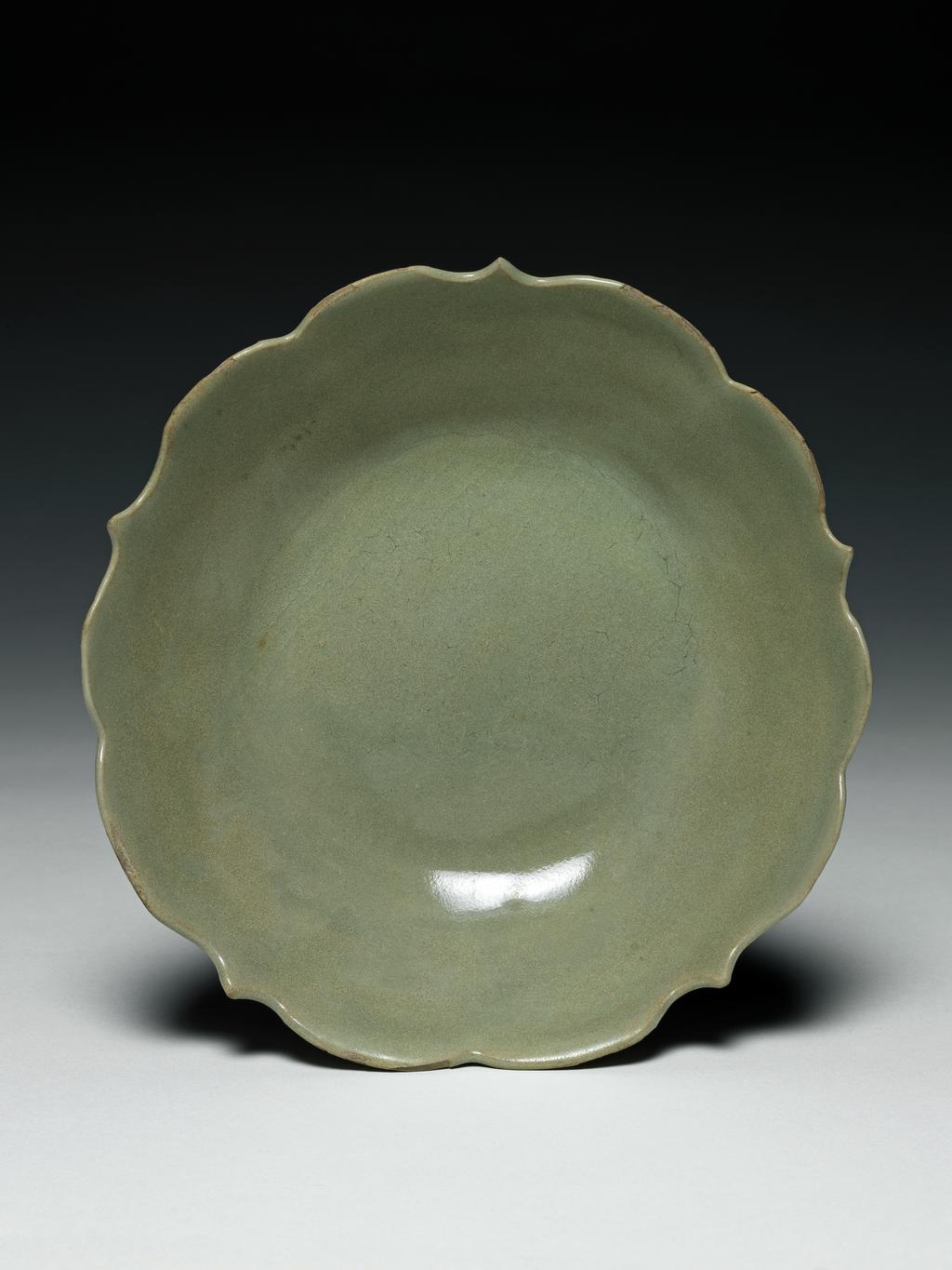 An image of Stoneware dish with a foliate edge. Yue ware. Diameter 15.6 cm. T’ang Dynasty (618-906). Chinese.