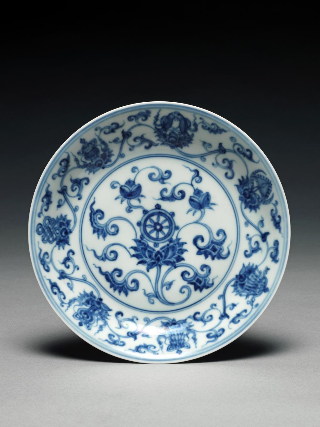 An image of Dish. Saucer dish. The dish is decorated with eight emblems of Buddhism among formalised lotus scrolls. Mark and period of Ch'eng Lua. Production Place: China. Hard-paste porcelain.