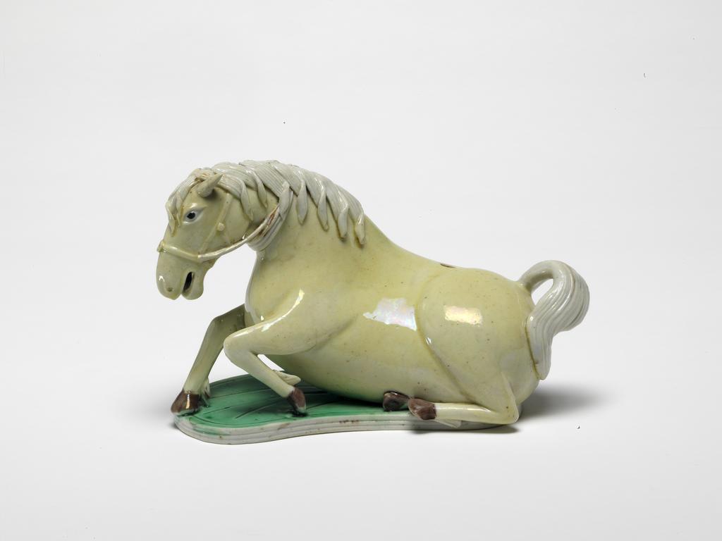 An image of Animal figure/Horse. Hard-paste porcelain, cream enamel on biscuit, length 11.4 cm. Chinese. Kangxi Period (1662-1722).