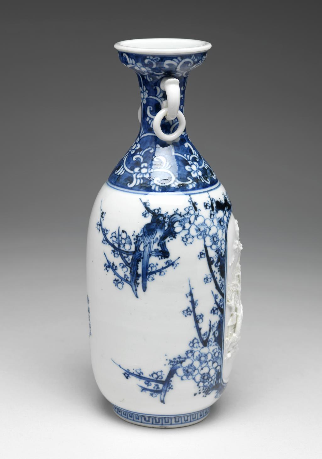 An image of Vase. Unknown maker. Blue and white hard paste porcelain vase with ring handles. Decorated with white high relief late Qing-style landscape. 1870. Meiji Period (1868-1912). Chinese. Acquisition Credit: Given by David Hyatt King, through The Art Fund.