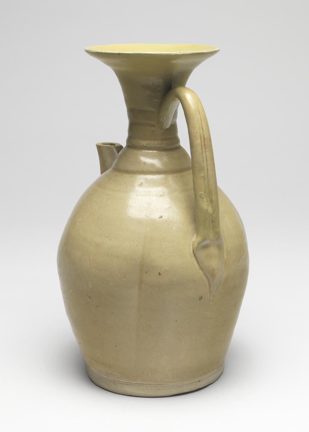 An image of Greyish white stoneware ewer. Changsha Kilns. Ovoid body with an outspreading neck, a large band loop handle, and a short octagonal spout. The body is decorated with underglaze painting of flower design in brown, just beneath the spout, and covered with yellowish green glaze. 610-907. Chinese. Tang Dynasty (618-907).