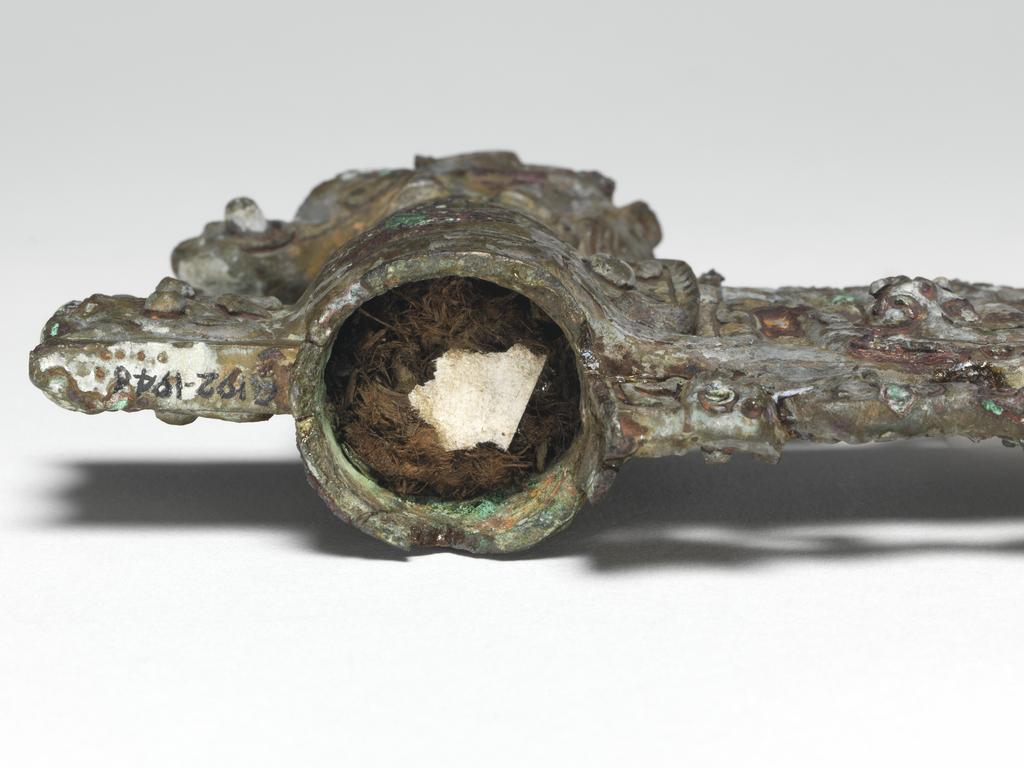 An image of Axe head. The blade, socket, and socket cap all one piece of metal. The blade is flanked by two tigers. On the blade is a coiled dragon, a conventionalised dragon's head, and a t'ao t'ieh mask in the piece of blade at the back. On the cap is an elephant's head with horse's legs and a tiger's head at the back. Bronze, height 11.1 cm, length 14.6 cm, circa 500-249 B.C. Chou dynasty (1122-249 BC). Chinese Warring States period.