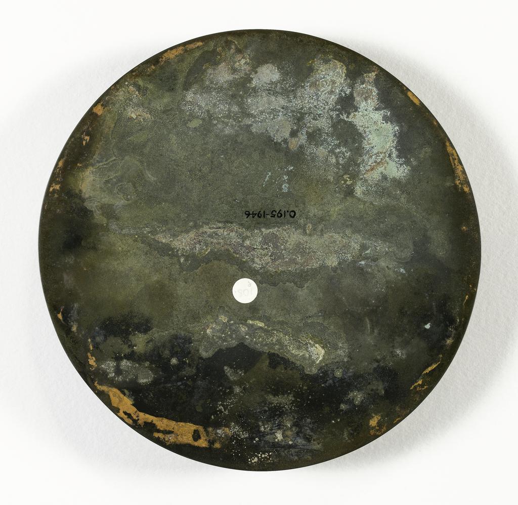 An image of Mirror made from bronze, of a glossy dark colour. Flanged edge, with mouth border. A wide band of much conventionalised dragons scrolled and intertwined, and a interlaced design on a diamond and spiral background. Inside is another smooth band, a hatched area, and the central boss-like loop for the cord. Bronze, diameter 18.3 cm. Chinese Period of the Warring States (481-221 BC).