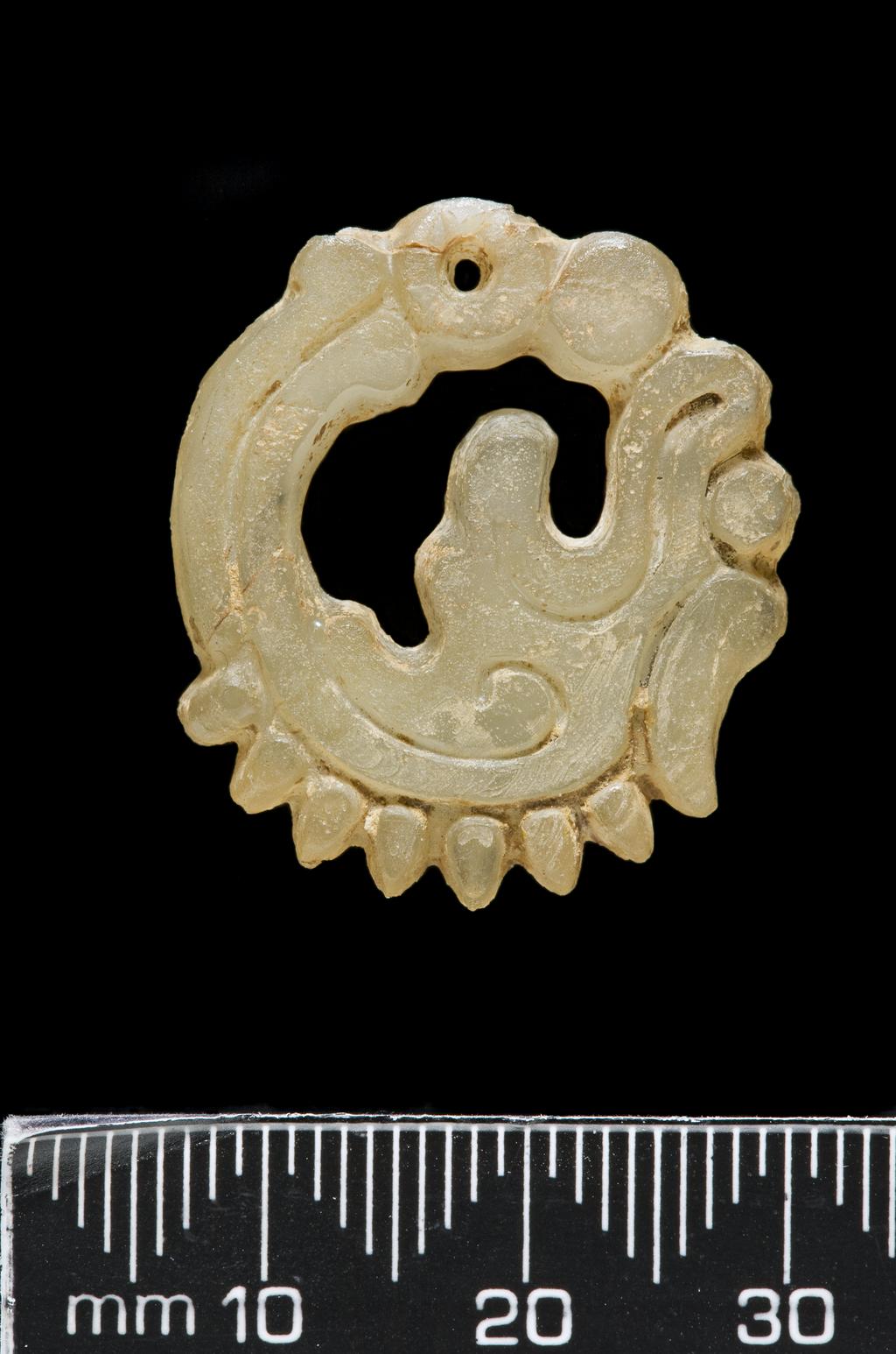 An image of Button, glass. In the form of a dragon, tail to snout. Stylised.Han Dynasty (BC 206 - AD 220)China
