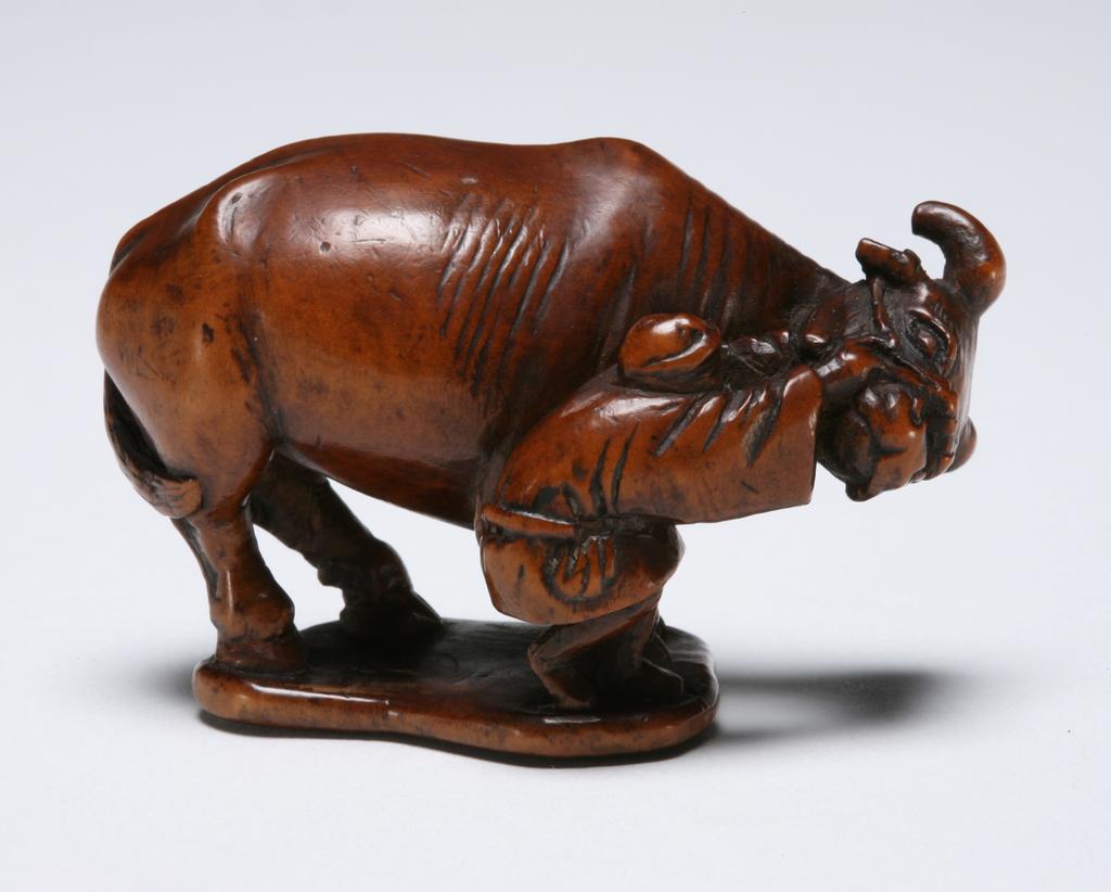 An image of Netsuke. A farmer pulling the ox’s harness and turning its head towards to the right. Unknown maker, Japan. Boxwood, carved, 1800-1850.
