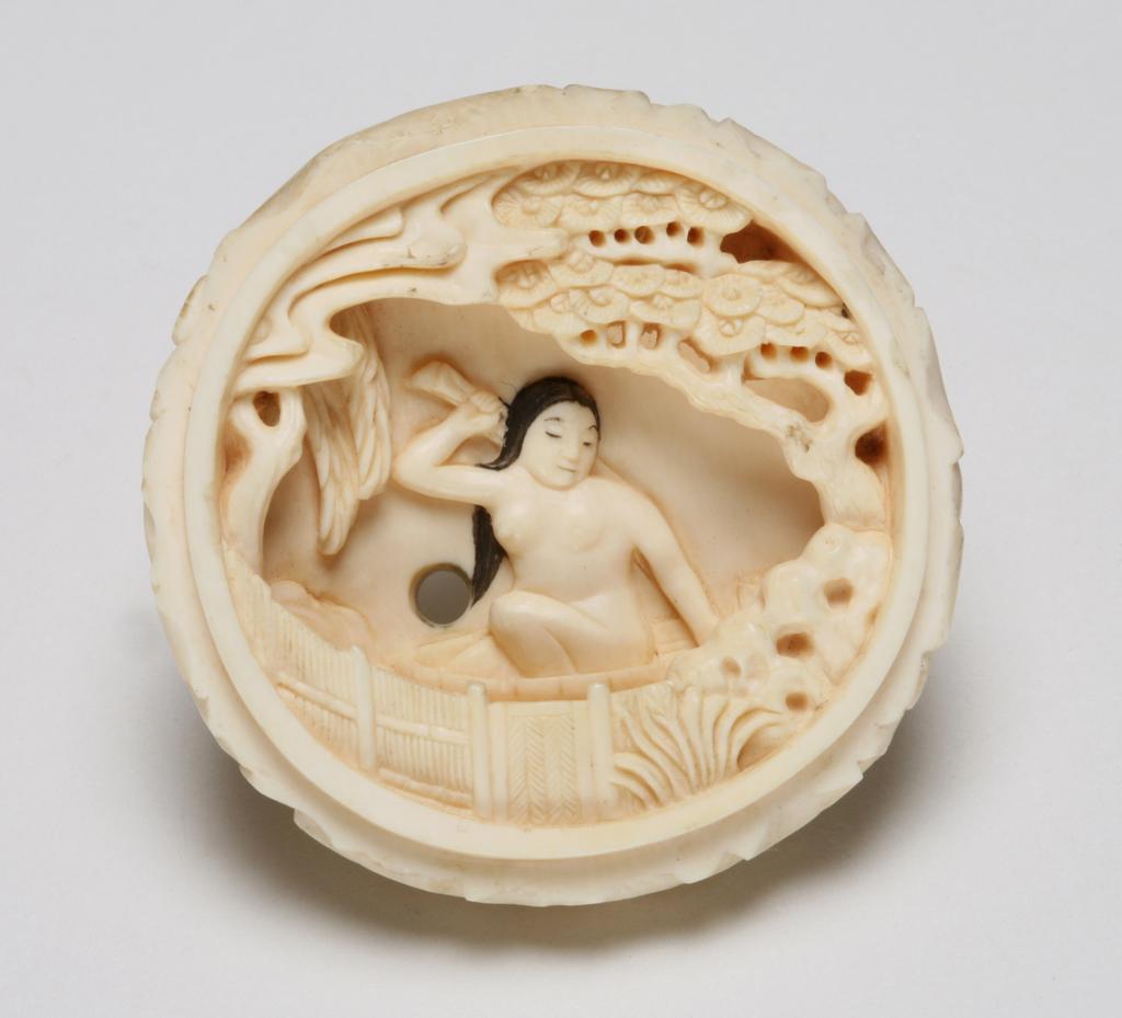 An image of Netsuke-Manju. Unknown maker, Japan. A man crouching and looking down on top of clouds, looking through the clouds to peep at a young lady bathing. This is a two piece Netsuke, the young lady inside. Ink detail at hair work. Ivory, carved, 1870-1930.