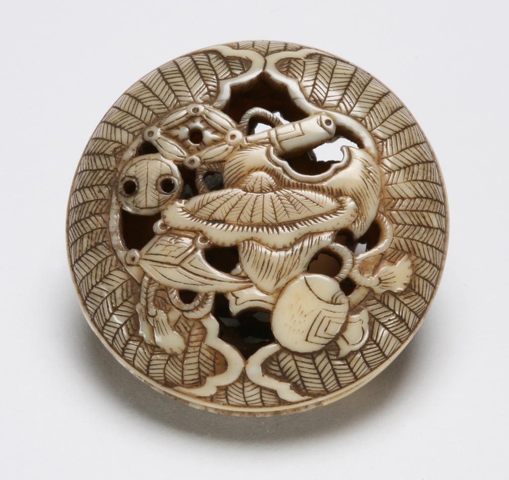 An image of Netsuke-Ryusa Manju. Unknown maker, Japan. Daikoku mallet, Hotei treasure sack, Minogame (a thousand year old turtle tail) straw hat and Mon (family crest), this is a two piece Netsuke. Ivory, carved, 1800-1850.