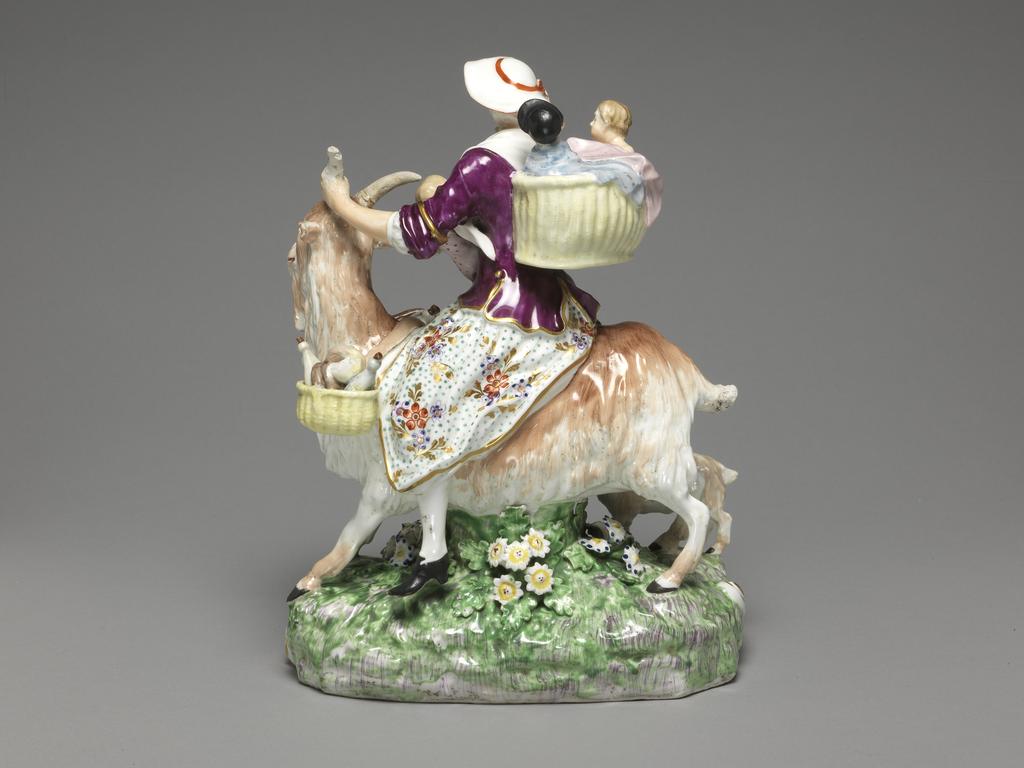 An image of Figure. Taylor's Wife and Family mounted on a Nanny Goat. Derby Porcelain Factory, England, Derbyshire. Kändler, Johann Joachim, modeller, after (German, 1706-1775). Eberlein, Johann Friedrich, modeller, after (German, 1696-1749). Soft-paste porcelain, slip-cast, with hand-modelled details, lead-glazed and painted in dark blue, green, yellow, flesh, pink red, purple, shades of brown, grey, and black enamels, and gilt. The underside has a large, central, circular ventilation hole. Most of the surface has been ground down, and is unglazed. Height, whole, 24.2 cm, circa 1800. Rococo.