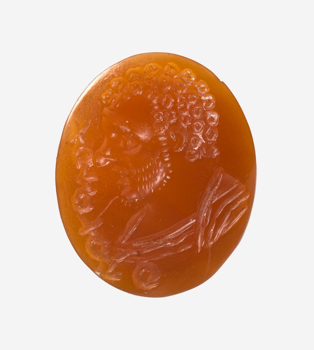 An image of Engraved gem. Ringstone. Intaglio. Male bust in profile to the right; the head has curly hair and the face has a light, stubbly beard and a prominent nose. The shoulders are draped. In front is a Bactrian inscription on palaeographic grounds. Intaglio cutting. Carnelian, height 18.5 mm, width 15 mm, circa 200-circa 400. Kushano-Sassanian. Alternative Number: gem catalogue number; CM.61.1967.
