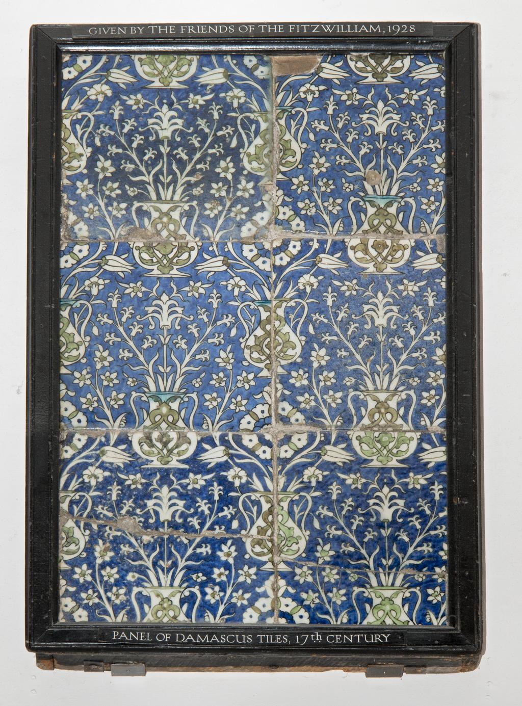 An image of Fritware (stonepaste) tile panel. Islamic pottery; Iznik style. Fritware, mould made, painted in blue and green with touches of turquoise and black outlines, all under a clear glaze. Height, whole, 76cm, width, whole, 50cm.  Ottoman, circa 1550-1699. Levant, Syria, Damascus.