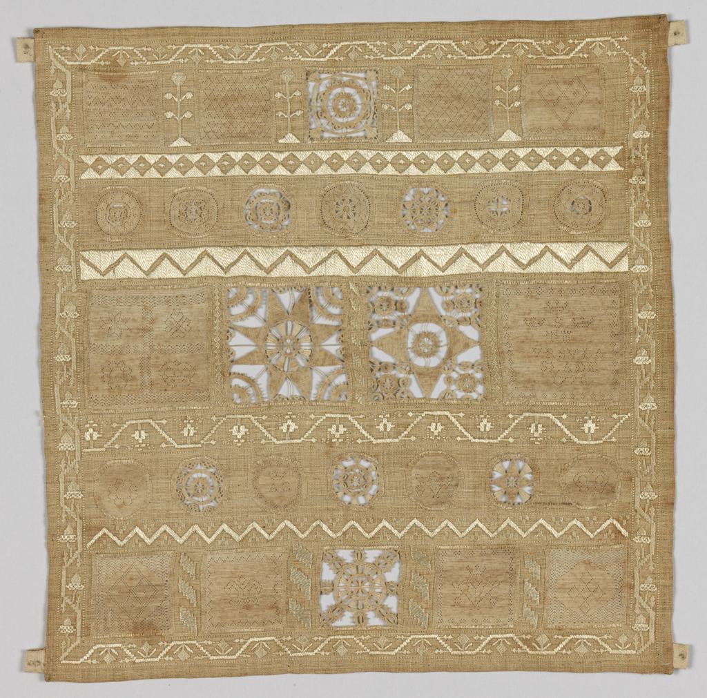 An image of Textiles. Whitework sampler. Slade, Ursula (English). The sampler is almost square in shape and is made up of inserted panels of hollie point and needle lace, neatly divided and bordered by repeat patterns in counted satin stitch. The sampler carries the inscription 'VrsVla/Slade' in the middle right panel. Linen embroidered with linen thread in satin and back stitch with hollie point and needle lace insertions. All the edges are hemmed. Length 21.75 cm, width 21 cm, 1728.