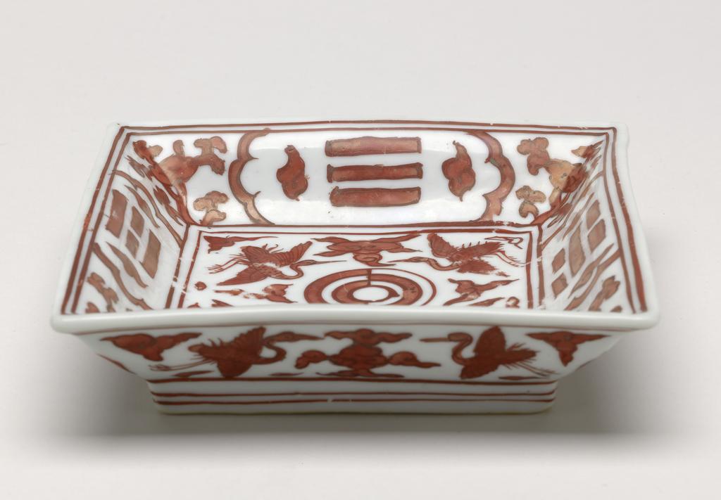 An image of Square iron red dish. Production Place: China. With cranes and trigrams (chip to rim and old restoration, rubbing to red on interior, another chip at foot corner), diameter 12.8 cm. Jiajing period (1522-1566).
